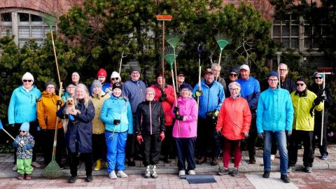 Siisteystalkoisiin osallistuneita henkilöitä seisoo kahdessa rivissä ja katsoo kameraan.