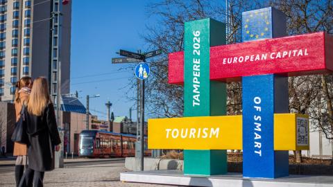 Passersby look at the Smart Tourism Capital statue.