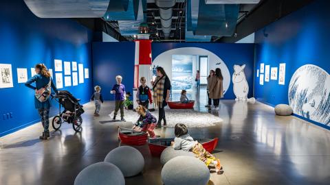 Taidenäyttelyn vieraat tutustuvat muumiteoksiin. 