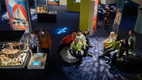 Ihmiset viettävät aikaa Muumimuseossa teoksia tutkien.