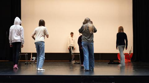 Five children stand on the stage.