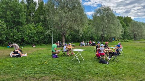 Ihmisiä ruokailemassa puistossa