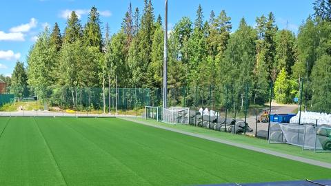 Kuvassa vihreää siirtonurmea, siirrettäviä rullia takana.
