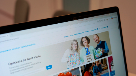 A computer screen displaying a website. Three people are smiling in the banner image.