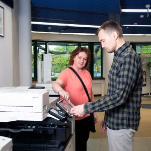 Two people at the printer.