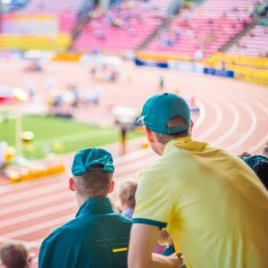 Kaksi ihmistä katsovat urheilukenttää.