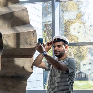 Aikuislukion opiskelija sovittaa ylioppilaslakkia.