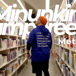 Mies katselee kirjoja kahden korkean kirjahyllyn välissä.