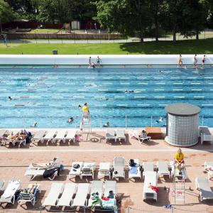 People in the sunny outdoor swimming pool.