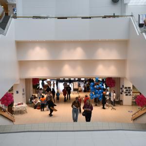 Sampolan aulassa kävelee ihmisiä ja käytävien reunoilla on ilmapalloja.