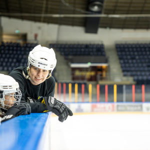 Äiti ja tytär katsovat toisiaan luistelukentän laidalla Hakametsän hallissa.
