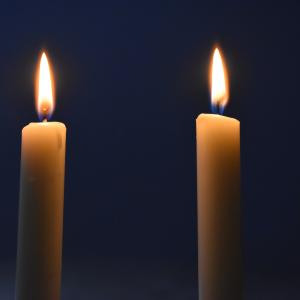 Kaksi valkoista kynttilää palamassa itsenäisyyspäivän kunniaksi.