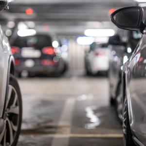 Henkilöautoja parkkiruuduissaan parkkihallissa.
