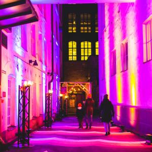Finlaysonin alueen kapea kuja on valaistu näyttävästi violeteilla ja oransseilla valoilla.