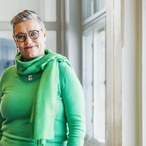 Henkilö seisoo ikkunan edessä ja katsoo kameraan.