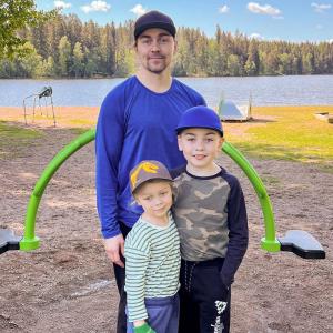 Isä ja kaksi lasta Peltolammin uimarannalla.