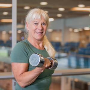 Iloinen nainen käsipaino kädessä 