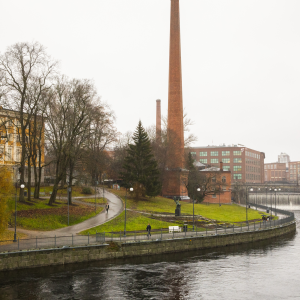 Maisemakuva, jossa Tammerkoski, punatiilinen piippu ja puiden takaa pilkottaa keltainen Vanha kirjastotalo.