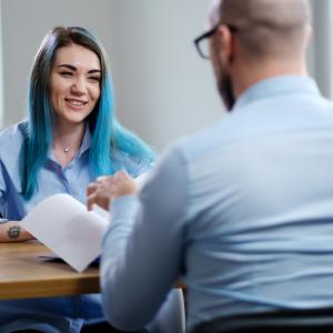 Sinihiuksinen nuori työpaikkahaastattelussa