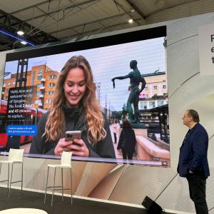 Näytölle heijastuu kuva naisesta, joka katsoo puhelintaan ja viereen nousee tekstikupla, joka kysyy mitä hän haluaisi tehdä kaupungissa.