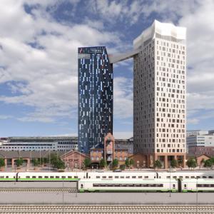 Kuvassa aseman miljootä, junia ja kaksi tornimaista taloa.