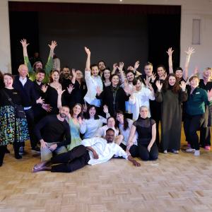 Iloisia ihmisiä poseeraa kameralla ryhmänä.