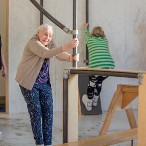 Neljä seniori-ikäistä naista liikuntasalissa.