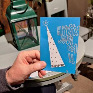 käsi pitelemässä joulukorttia