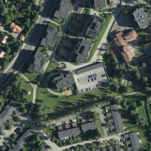 Ilmakuvassa paljon vihreää ja puita, taloja ja katuja.