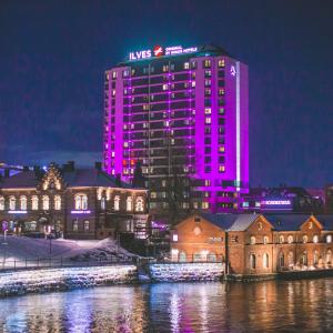 Hotelli Ilves kuvattuna iltaaikaan Hämeensillalta violetiksi valaistuna.