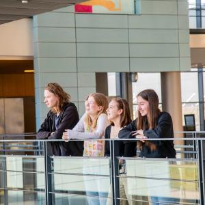 Neljän opiskelijan ryhmä Sammon lukion avarassa aulassa katsomassa kaukaisuuteen.