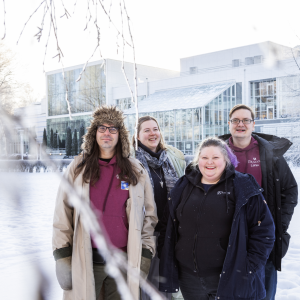 Neljä ihmistä katsoo kameraan talvisessa Sorsapuistossa.