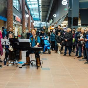 The choir performs in the lobby of the shopping center.