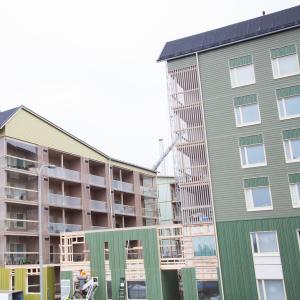 Puukerrostalojen rakennustyömaalla nousee erivärisiä taloja.