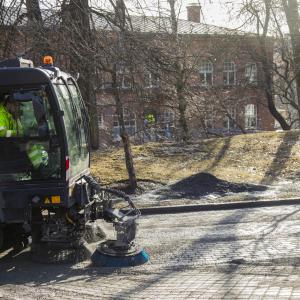 Harjauskone putsaa kävely- ja pyörätietä Frenckellin rakennuksen edustalla keväällä.