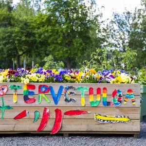 A planter box with a colorful welcome message on the side.