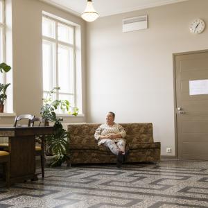 Annamaija Saarela sits on a sofa in the hallway of the Nekala Cultural Center.