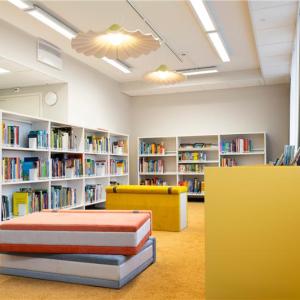 Yleiskuva Nekalan kirjastosta. Isoja kirja-aiheisia kalusteita ja kirjahyllyjä.