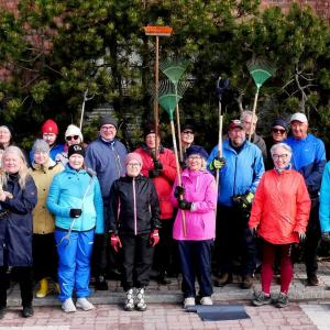 Siisteystalkoisiin osallistuneita henkilöitä seisoo kahdessa rivissä ja katsoo kameraan.