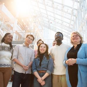 Eight Tampere residents from different cultural backgrounds stand side by side.