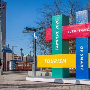 Passersby look at the Smart Tourism Capital statue.