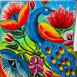 Sini- ja punasävyinen maalaus riikinkukosta.