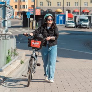 Henkilö taluttaa kaupunkipyörää Laukonsillalla. 