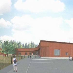 Suunnittelukuva vaaleanruskeasta puupintaisesta päiväkotirakennuksesta. kesämaisemassa.