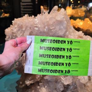 Green Night of Museums wristbands on person's hand.