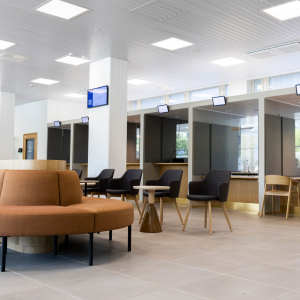 The customer service area has a curved bench and groups of tables in the front. In the background are customer service desks.