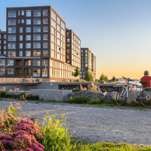 A cyclist sitting on a stone in Ranta-Tampella admiring sunset.