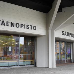 Entrance to the building. Three large windows. On the wall is the inscription "Työväenopisto".