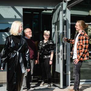 Eri ikäisiä opiskelijoita Aikuislukion ulko-ovella.