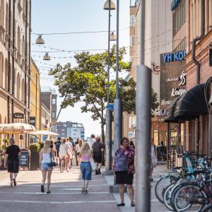 Ihmiset kulkevat kesäisellä kadulla kaupungissa.